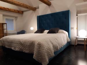 多莫多索拉appartamenti e camere Hippy Chic的一间卧室配有一张大床和蓝色床头板