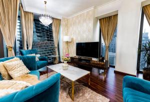 迪拜FIRST CLASS 3BR with full BURJ KHALIFA and FOUNTAIN VIEW的客厅配有蓝色的家具和平面电视。