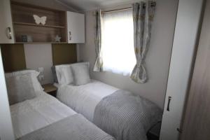 博特夫加滕The One - Chalet in the Cairngorms的一间小卧室,配有两张床和窗户