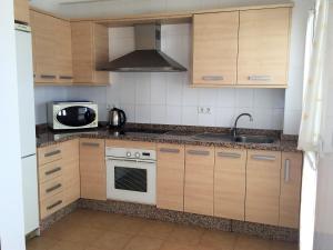 隆达龙达市中心公寓的厨房配有木制橱柜、水槽和微波炉