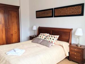 隆达龙达市中心公寓的一间卧室配有一张带木制床头板的床