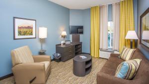 西德尼悉尼坎德尔伍德套房酒店的酒店客房设有一间带沙发和椅子的客厅