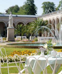 巴特基辛根Villa Thea Hotel am Rosengarten的喷泉前的桌椅