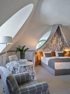 德累斯顿德累斯顿皮尔尼茨城堡酒店的一间卧室配有一张床、一张桌子和一张沙发