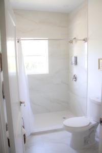 迈阿密Spacious and Comfy Suite near MIA - 6G的白色的浴室设有卫生间和淋浴。