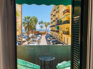 马拉加Apartamento a 50 metros de la playa malagueta con vistas al mar的阳台配有桌子,享有停车场的景致。