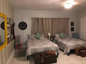 迈阿密Spacious and Comfy Suite near MIA - 6G的一间卧室设有两张床,墙上挂着一个时钟。