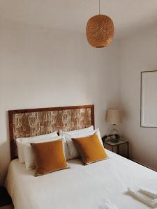 卡帕里卡海岸Maria Tereza Sea Villa的卧室配有带橙色枕头的大型白色床