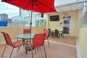 布卡拉曼加La Pera Hotel的庭院里配有桌椅和红伞