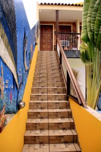 马拉戈日Camping e Chalés Beira Mar的通往一个黄色和蓝色墙壁的房子的楼梯