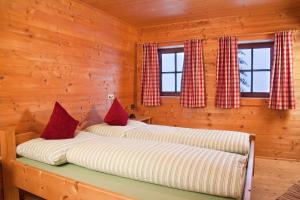 阿尔卑巴赫Appartement Rossalm mit Sauna的小木屋设有2张床和窗户。