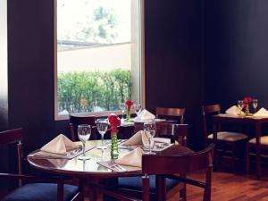 圣保罗圣保罗保利斯塔美居酒店的用餐室配有带酒杯的桌子