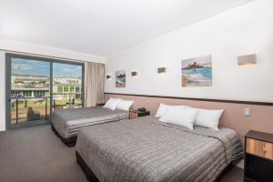 华纳海湾Macquarie 4 Star的酒店客房设有两张床和一个阳台。