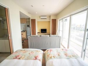 北谷町北谷海滨公寓的配有两张床的房间,设有厨房和客厅