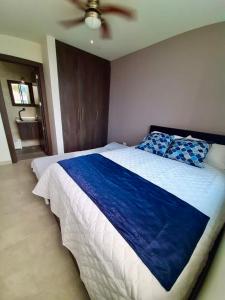 通苏帕DEPARTAMENTO TOTALMENTE NUEVO, AMOBLADO Y DE LUJO EN TONSUPA的一间卧室配有一张带蓝色毯子的大床