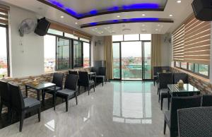 海防MV Hotel的餐厅设有桌椅和窗户。