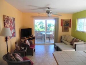 Kehena科合纳海滩度假屋的客厅配有沙发、椅子和电视