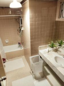 克提FAMISA Eastern Gold Service Apartment的浴室配有盥洗盆、卫生间和浴缸。