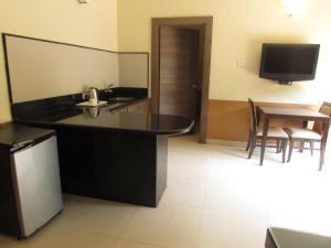 帕纳吉Sandalwood Hotel & Suites的厨房配有黑色台面和桌子