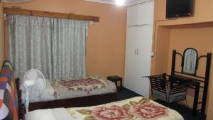 卢萨卡燧石背包客旅舍的一间卧室设有两张床、一张桌子和一个窗口。