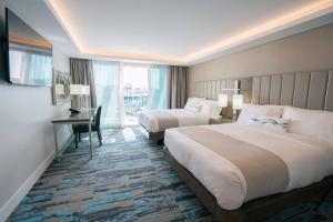 贺茂沙海滩H2O Hermosa的酒店客房配有两张床和一张书桌