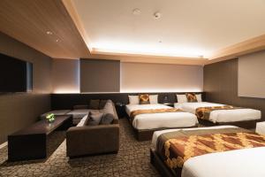 鹿儿岛GRAND BASE Kagoshima的酒店客房设有四张床和平面电视。