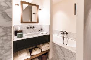 根特1898波斯特酒店的一间带水槽、浴缸和镜子的浴室