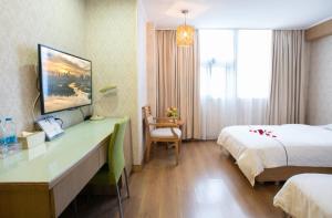 广州广州新粤新酒店的酒店客房配有一张床、一张书桌