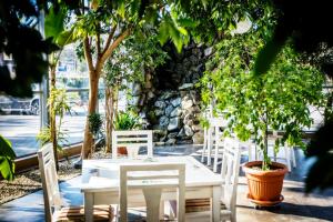 拉多姆Hotel LUKA的庭院里设有白色的桌椅和树木