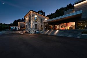 拉特乌伊莱Re Delle Alpi Resort & Spa, 4 Stelle Superior的前面有楼梯和灯的建筑