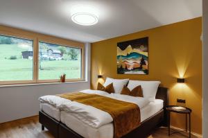 瓦尔德阿尔贝格Verwall Apartment Arlberg - mit Sauna, Balkon und Gästekarte Premium的一间卧室设有一张大床和一个大窗户