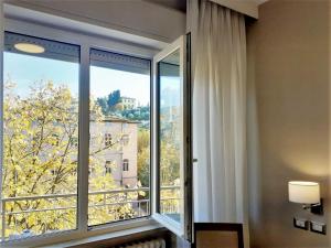 特拉西梅诺湖畔帕西尼亚诺利多酒店的客房设有享有美景的大窗户。