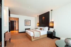 迪拜迪拜阿尔巴沙假日酒店的酒店客房设有一张大床和一张书桌。