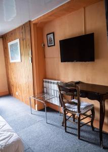 鲁瓦昂地区蓬博里瓦奇酒店的一间房间,配有一张桌子和一台墙上的电视