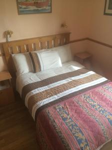伊尼什莫尔岛莫里斯博物馆住宿加早餐旅馆的一间卧室配有一张大床和木制床头板