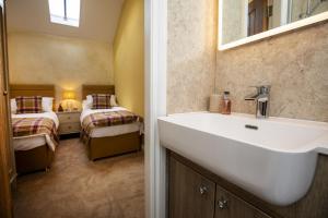 斯卡伯勒Thirley Cotes Farm Cottages的一间带水槽的浴室和一间带两张床的卧室