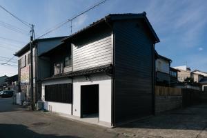 金泽B&B MIKAWA Info Centre - Kanazawa Fish Harbour的一座黑白的建筑,设有车库