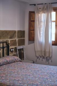 Huerta del MarquesadoCasa rural fuentelgato的一间卧室配有床和带窗帘的窗户