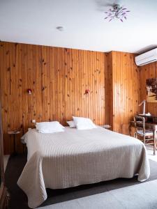 鲁瓦昂地区蓬博里瓦奇酒店的一间卧室配有一张木墙床