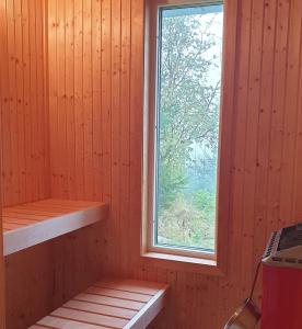 布罗斯Gäststuga i vacker natur, bastu, bubbelpool sommartid och gratis parkering, guesthouse with nice view with sauna and free parking close to Dalsjöfors and fishing的一个带窗户和木墙的桑拿浴室