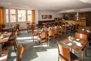斯图加特凯莱高级酒店的用餐室配有木桌和椅子