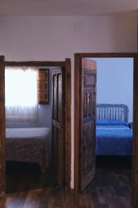Huerta del MarquesadoCasa rural fuentelgato的一间卧室设有两张床和一扇开放式门