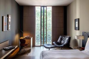 巴塞罗那巴塞罗那GL阿尔玛酒店的卧室配有一张床和两把椅子,位于窗户前