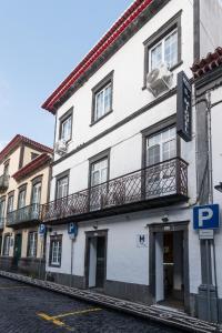 蓬塔德尔加达Hotel São Miguel的街道上带阳台的白色建筑