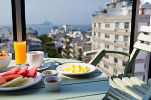 里约热内卢莱布隆丽思酒店的阳台上的桌子上备有鸡蛋和水果的早餐
