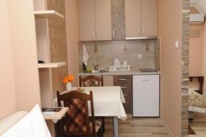查查克Favorit Apartments Čačak的小厨房配有白色的桌子和椅子