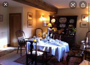 谢菲尔德Loadbrook Cottages的一间用餐室,配有一张带白色桌布的桌子