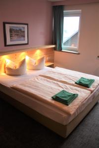 奥泊维森塔尔Ferienstudio的一间卧室配有一张大床,上面有两条绿色毛巾