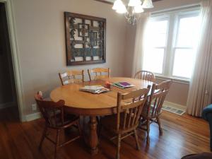 罗切斯特Covered By Faith Rentals -Storybook Home的餐桌、椅子和木桌
