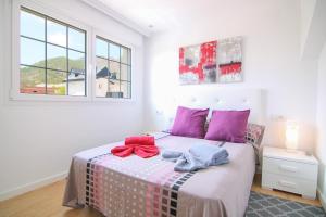 波洛普Villa con piscina privada - Polop的一间卧室配有带粉红色和蓝色毛巾的床